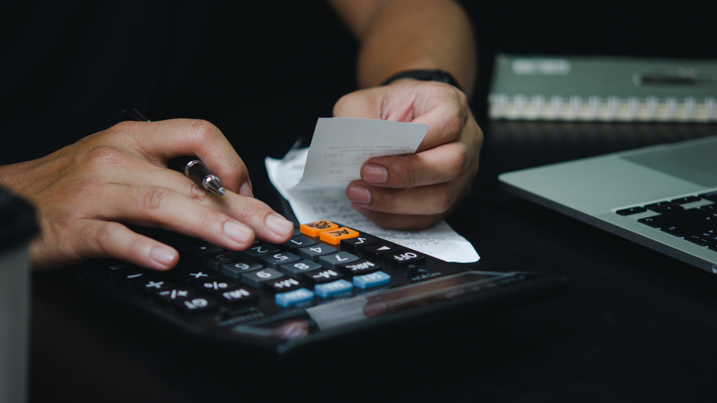 Travelers reviewing vacation costs on a calculator