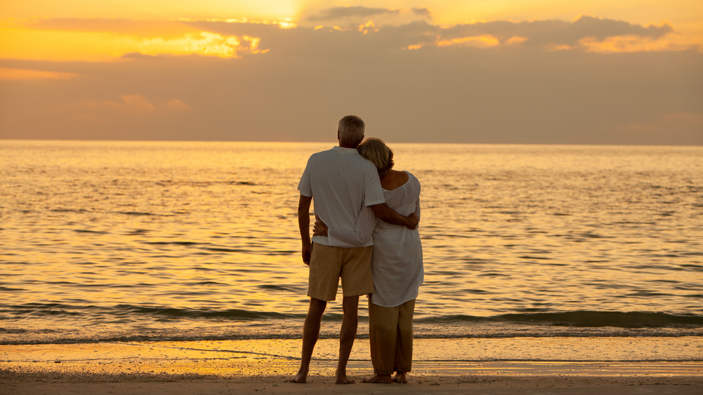 Couple relaxing together on a beach at sunset